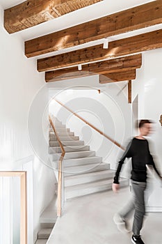 minimalist interior design, white walls with wooden beams on the ceiling, wood staircase, light brown stairs handrail