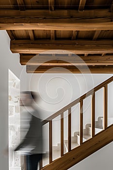 minimalist interior design, white walls with wooden beams on the ceiling, wood staircase, light brown stairs handrail