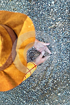 Minimalist low angle view of kid playing with sand. Childhood creativity concept