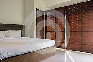 Minimalist master bedroom with large brown curtains.
