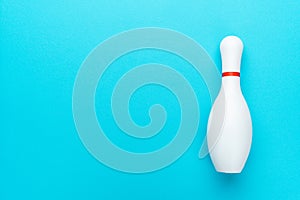 Minimalist photo of bowling pin over turquoise blue background