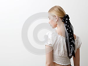 Minimalist photo, Fashionable girl in stylish summer things . View from the back. Earrings, a ring , a scarf on her head