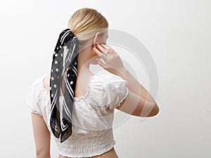 Minimalist photo, Fashionable girl in stylish summer things . View from the back. Earrings, a ring , a scarf on her head