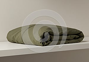 Minimalist Presentation of an Olive Green Folded Textile on a Plain Surface