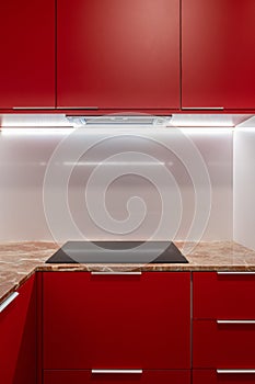 Minimalist red kitchen cabinet design with sleek handles and marble countertop