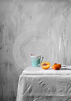 Minimalist still life with peaches and blue mug