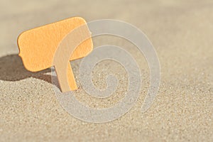 Minimalist summer background, a blank sign buried in the beach sand