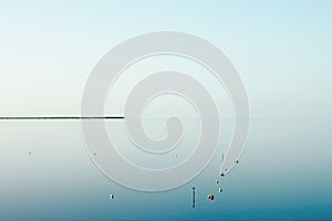 Minimalist view in Florida Keys looking out at the horizon with tiny stip of land and floats in the water