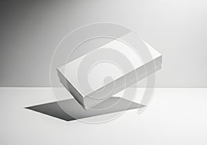 Minimalist white rectangular object casting a shadow on a plain surface isolated on white background
