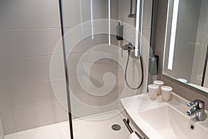 Minimalistic bathroom with shower and paper cups on the sink