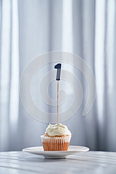 Minimalistic birthday cupcake with number 1 one on plate