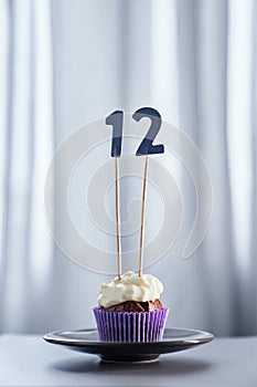Minimalistic birthday cupcake with number 12 twelve