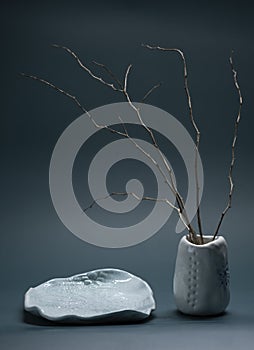 Minimalistic composition in Japanese Asian style with ikebana in an earthenware clay handmade vase and plate photo