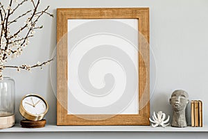 Minimalistic concept on the shelf with brown mock up photo frame, dired flower in vase, gold clock, book.