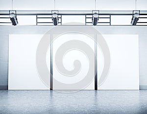 Minimalistic empty gallery hall with three blank vertical banners and spotlight