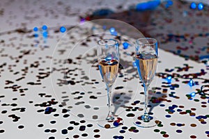 Minimalistic festive background with champagne in glasses and confetti