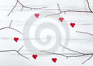 Minimalistic frame with branches and hearts on white table. Flat lay, top view