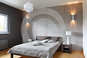 Minimalistic grey bedroom with double bed and concrete wall