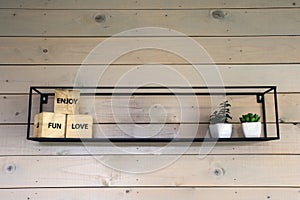 Minimalistic rack on wooden wall with decoration for modern home, little green plants closeup
