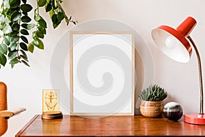 Minimalistic and stylish mock up poster frame concept with retro furnitures, hanging plant, table lamp, decoration.