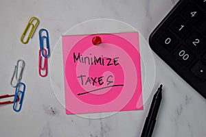 Minimize Taxes text on sticky notes isolated on office desk