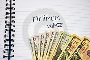 Minimum wage handwriting  text on paper, on office agenda. Copy space