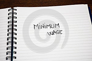 Minimum wage handwriting  text on paper, on office agenda. Copy space