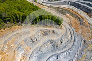 Mining from above. Industrial terraces on open pit  mineral mine. Aerial view of opencast mining. Dolomite Mine Excavation.