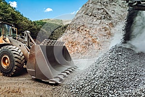 Mining and construction industry - Heavy duty wheel loader bulldozer loading granite rock