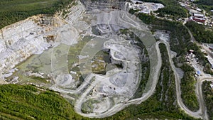 Mining dump trucks in the open pit mine. Loaded truck rides on the road quarry. The truck in course of work. 4K footage from drone