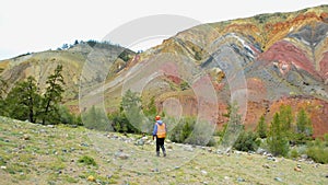 Mining engineer, a geologist in the protective reflective vest, gloves and helmet, with hammer in hand.