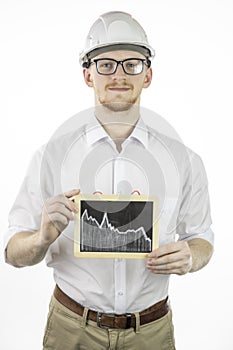 Mining engineer holding tablet with falling graph, looks at camera with smile