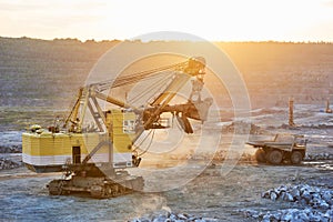 Mining. excavator and dump truck in granite or iron opencast