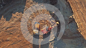 Mining excavator load the sand into dump truck in open pit. Developing the sand in the opencast. Heavy machinery on earthworks in