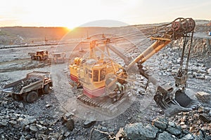 Mining. excavator loading granite or ore into dump truck