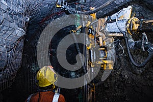 Mining operator on mining machine, underground mine mesh.