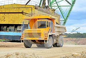 Mining truck and excavators working in the limestone open-pit. Loading and transportation of minerals in the dolomite mining