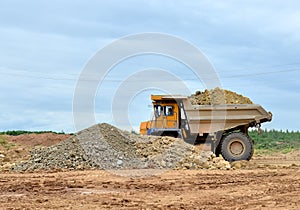 Mining truck and excavators working in the limestone open-pit. Loading and transportation of minerals in the dolomite mining