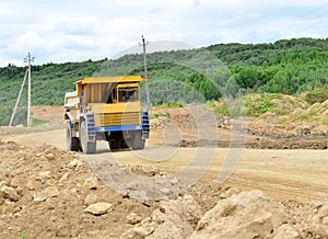 Mining truck working in the limestone open-pit. Loading and transportation of minerals in the dolomite mining quarry