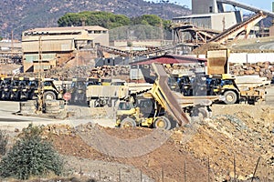 Mining trucks and machinery in Corta Atalaya open mine pit. Deep excavation of pyrite and extraction of minerals of cooper and