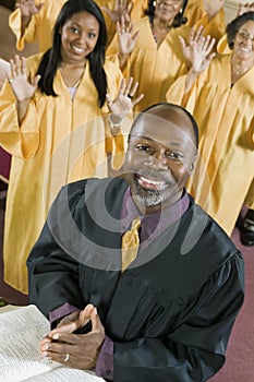 Minister at altar with Bible gospel choir in background portrait photo