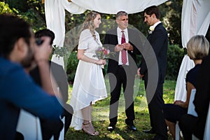 Minister giving speech to bride and groom