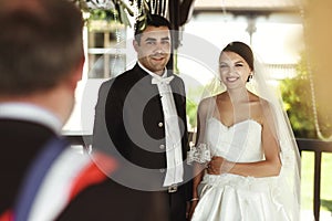 Minister providing wedding ceremony for married couple under arbor