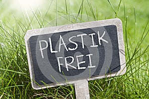 Minitature chalkboard in the grass with message plastic free