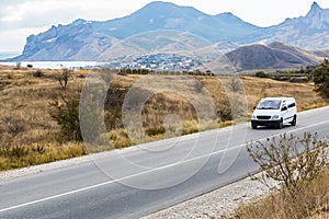 minivan is moving on a country road in a mountainous area