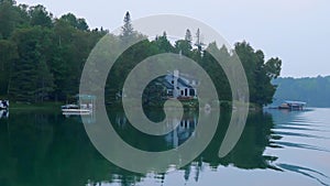 Minnesota lake shore with boats and cabins in evening light.