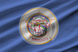 Minnesota US state flag with big folds waving close up under the studio light indoors. The official symbols and colors