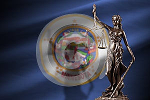 Minnesota US state flag with statue of lady justice and judicial scales in dark room. Concept of judgement and