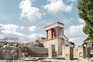 Minoan palace Knossos at Heraklion, Crete island, Greece. Bull fresco and three red columns against dramatic cloudy sky