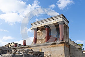 Minoan palace Knossos at Heraklion, Crete island, Greece. North Entrance with charging bull fresco and three red columns